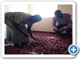 The Head teacher (L) of Ocoko primary school showing a section of onions harvested from the parent – led established school garden in the store. Looking on (R) is the Training Officer of HEAR INTERNATIONAL Mr. Okuti Stephen.
